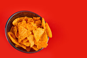 Bowl of crispy chips on red background