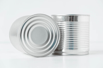 Obraz premium Two aluminum closed metal cans on a white table. Copy, empty space for text