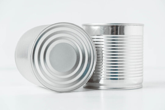 Two aluminum closed metal cans on a white table. Copy, empty space for text