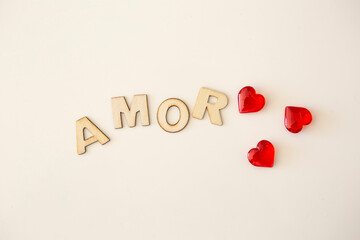 wooden letters with the word "amor" written on white background and red heart