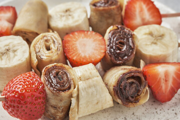 Skewers of pancakes crepes with nut butters and fruits