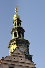 Fototapeta na wymiar Rathausturm mit Uhr und goldener Wetterfahne vor strahlend blauem Himmel