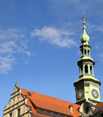 Schlanker, grüner Rathausturm vor strahlend blauem Himmel