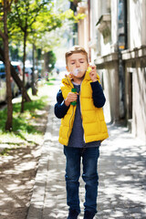 Small boy blowing bubbles with bubble wand outdoors.