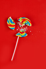 Colorful cracked lollipop on red background