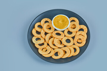 Cracker rings with a sauce on a ceramic plate