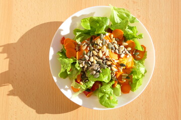 Healthy mixed salad rich in vitamins and low in calories with carrots, pine nuts and pumpkin seeds