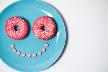 Fototapeta na wymiar Pink donuts on the pastel plate