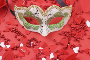Beautiful carnival venice mask with hearts red background.Holiday decorations backdrop.