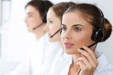 Call center. Beautiful young woman using headset and computer to help customers. Business concept