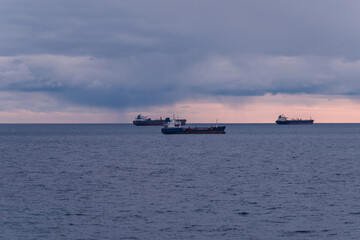 Three merchant ships on calm waters at sea