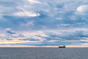 Obraz premium the ship sails on the sea against the backdrop of a beautiful cloudy sky.