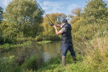 Young man fishing on the river. Outdoor recreation.