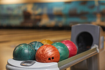 Fototapeta na wymiar Background image of several bowling balls on rack in bowling alley center, copy space