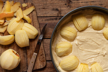 Vorbereitung zum Backen eines Kuchens mit Obst in der Küche mit Utensilien Springform, Teig und...