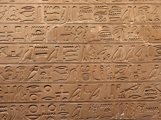Egyptian hieroglyphs on a stone wall. The language of an ancient civilization.