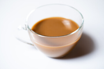 Clear glass of white coffee on white background