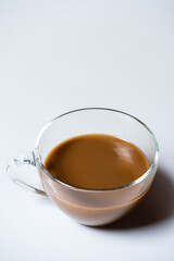 Clear glass of white coffee on white background
