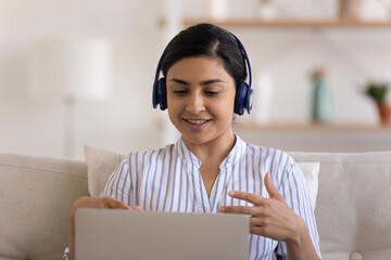 Young indian female specialist in headset participate in remote work conference express point of...