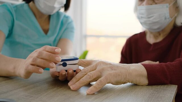 Close up view of pulse oximeter used on old patient during appointment in medical clinic