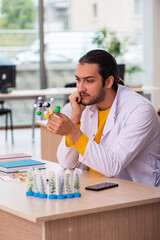 Young male chemist in drug synthesis concept