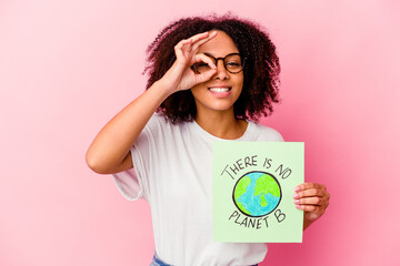 Young african american mixed race woman holding a world protection concept cardboard excited...