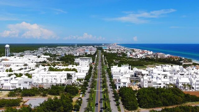 Aerial View of Alys Beach slowly lowering to show the entrance, a lot of white modern houses on the Gulf of Mexico near Seaside and Destin Florida.