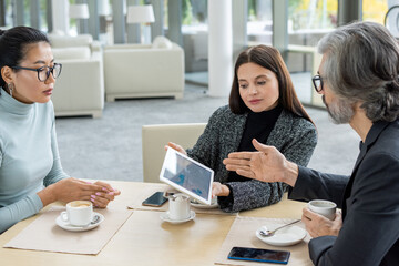 Elegant brunette businesswoman with tablet making presentation of her ideas