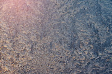Frozen surface with icy pattern on window glass in cold winter day