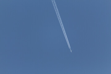 Estela de un avión sobre el cielo azul sin nubes. Horizontal.