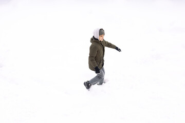 Fototapeta na wymiar Conceptual image of boy runnin lying down on the ground covered with snow isolated on white, top view from drone
