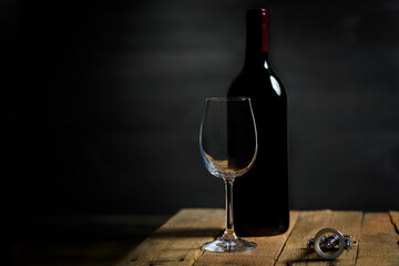 A bottle of wine on a wooden table in a dark cellar