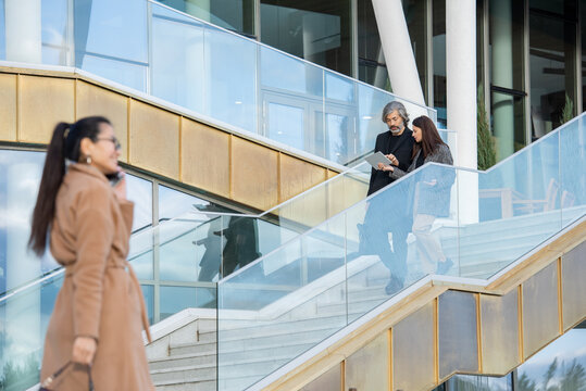 Contemporary brokers or bankers in smart casualwear discussing financial data - Powered by Adobe