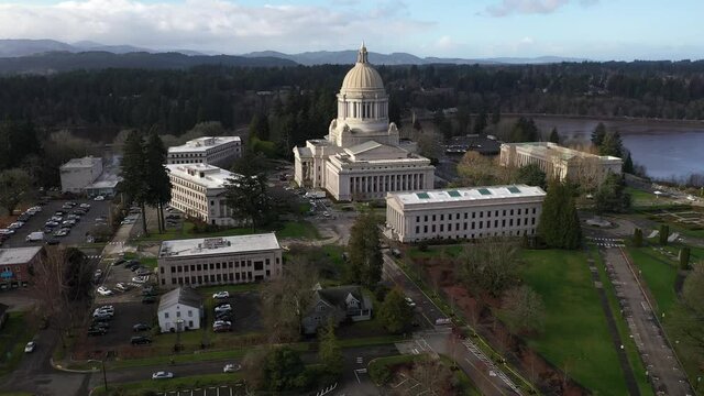 Cinematic aerial - drone orbiting footage of the Washington State Capitol Building and Campus, Capitol Lake, Tivoli Fountain and surrounding campus in Olympia, Washington