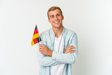 Young caucasian man holding a german flag isolated on white background - obrazy, fototapety, plakaty