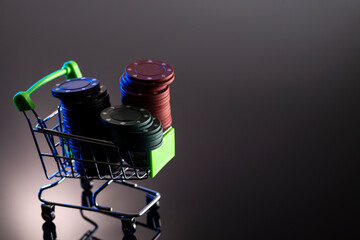 Casino chips in a shopping basket on a dark background with reflection