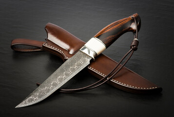 Hunting knife handmade on a black background. Leather Sheath Handmade