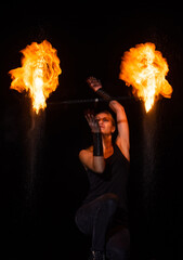 Burning desire. Sensual woman twirl flaming baton in darkness. Fire performance.