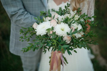 Wedding bouquet in the hands of the bride and groom.