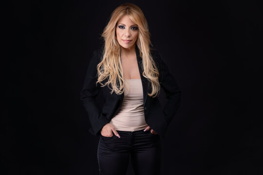 Blonde woman, business woman, middle-aged, European-Portuguese, posing with positive emotions on a black background.