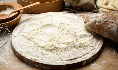 white wheat flour and wooden rolling pin on board, baking ingredients