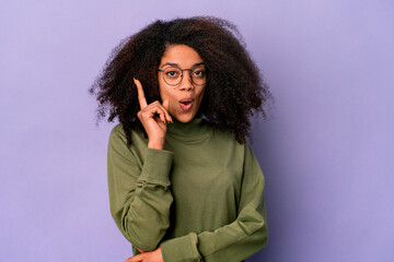 Young african american curly woman isolated on purple background having some great idea, concept of creativity.
