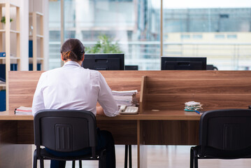 Young male employee and too many work in the office