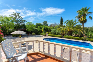 View from the terrace to the luxury pool with clear water in the garden. For tourists.