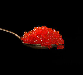 fresh grainy red chum salmon caviar in a metal spoon, delicious and healthy food