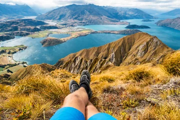 Outdoor-Kissen Abenteuer- und Wanderlustreise-Urlaubskonzept mit Wanderer-Wanderschuhen aus nächster Nähe. Wanderer, der die Aussicht von der berühmten Wanderung zum Roys Peak auf der Südinsel, Neuseeland, betrachtet. Ausruhen und Entspannen. © Maridav