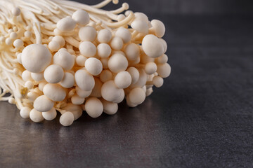 Fresh Enoki mushrooms on black background with selected focus.Enoki, also known as velvet shank, is a species of edible mushroom in the family Physalacriaceae.