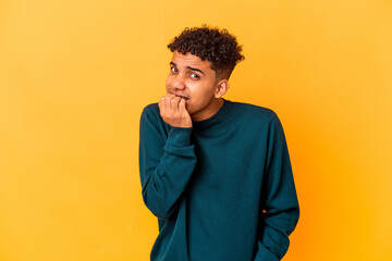 Young african american curly man isolated on purple biting fingernails, nervous and very anxious.