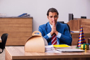 Young male employee celebrating Christmas at workplace