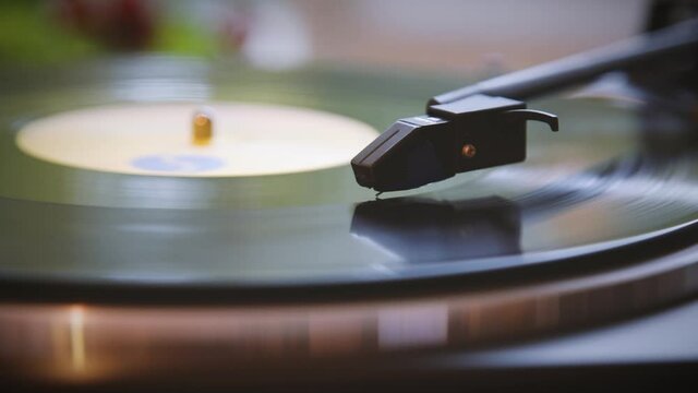 The needle rises from a vintage vinyl record. The vinyl record has stopped. The vinyl record is spinning. The needle plays on a vintage vinyl record. Old turntable. Vintage